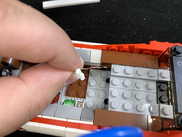 As shown in the first photo, pull the wire up through the space above the wheel well.