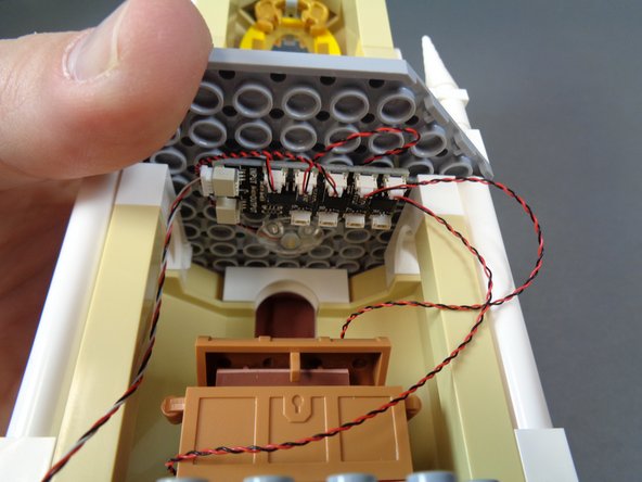 As shown in the photos for this step, use a large sticky square to mount the BRANCH09X adapter board to the ceiling of the lower room.