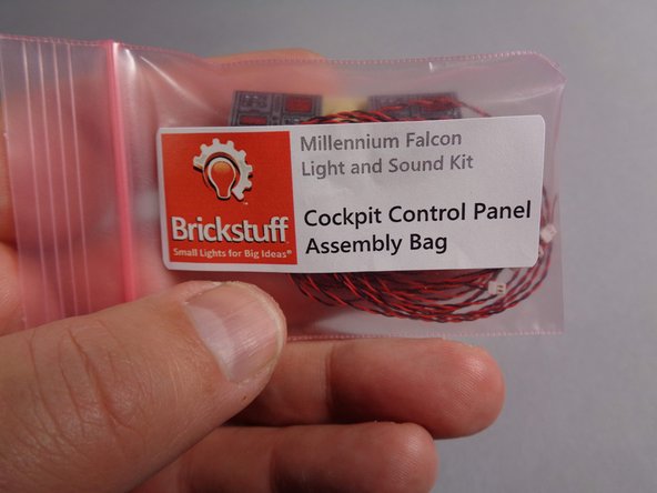 From your upgrade kit, take the small pink bag labeled &quot;Cockpit Control Panel Assembly,&quot; remove the new cockpit panel, and attach it as shown in the third photo.