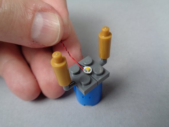 As shown in the first photo for this step, take the second warm white Pico LED from the bag in BOX #2 and place it flat in the center of the base.