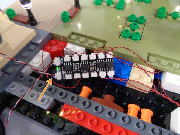 As shown by the orange arrow in the second photo for this step connect this shorter control cable to the OUTPUT plug on the BRANCH12X driver board.