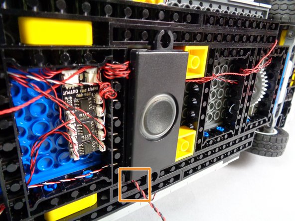 As shown in the third photo for this step, firmly press the speaker down on top of the two 1x2 plates you mounted in the previous step to attach it to the bottom of your Ecto-1.