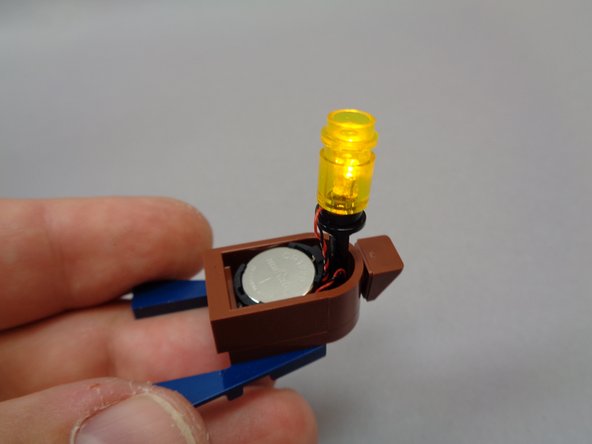 Insert a battery into the holder, and the lantern should turn on and begin flickering.