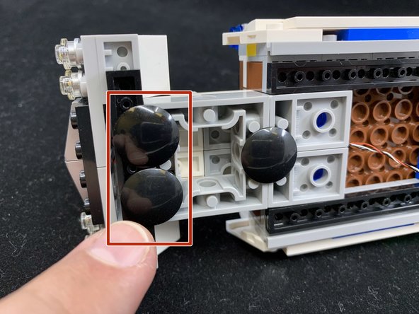 Remove the two black &quot;boat stud&quot; pieces from the bottom of the original hood assembly and attach them to the Brickstuff assembly as shown in the first photo by the red square.