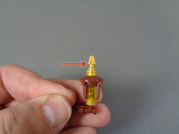 You may need to use some force to insert the brown part.  The LED light wires are strong enough to be squeezed between the brown and gold pieces.