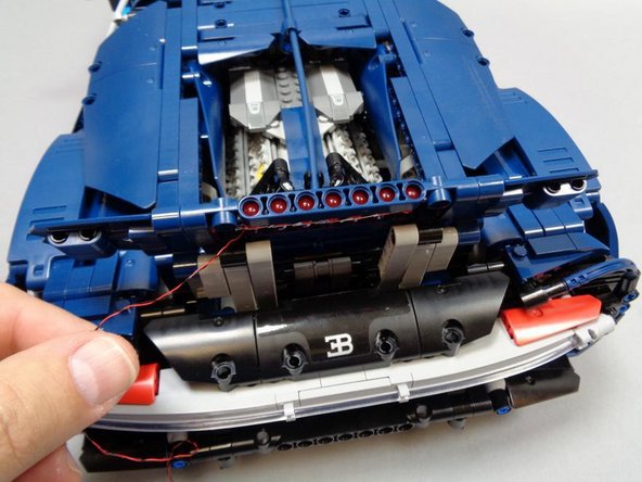 Be careful to loop the wires only through the innermost Technic beam and not through the outer beams.  This is so the spoiler will still be able to open and close smoothly without pinching any wires.