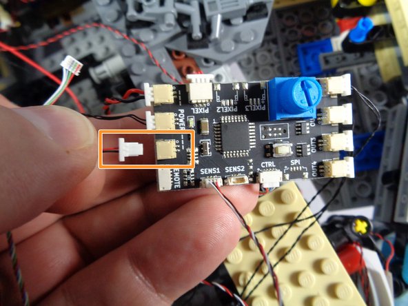 As shown by the orange rectangle in the first photo for this step, connect the larger plug coming from the RF receiver to the last open POWER connector on the new TRUNK08 controller.
