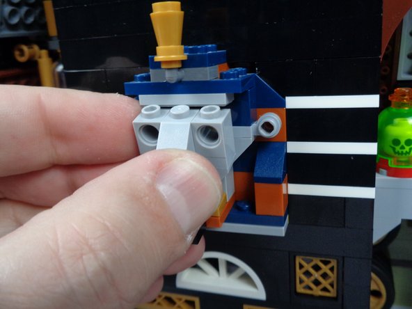 As show in the photos for this step, press upward on the top of the pharaoh's headgear to make room to remove the face parts.