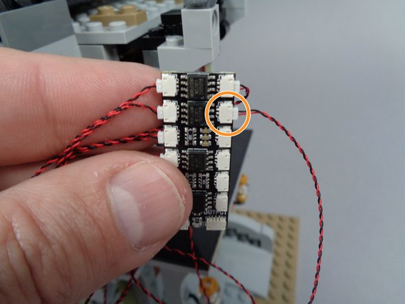 As shown by the orange circle in the first photo for this step, connect one of the sconces to plug #8 on the BRANCH12X adapter board.