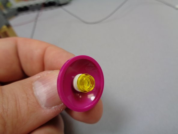 As shown in the second photo, replace the transparent yellow plate you removed earlier, placing it on top of the white plate.  The light should now be centered beneath both plates in the center of the dome.