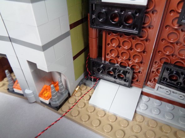 As shown in the first photo for this step, make sure the front door can open and close freely without pinching the light wire.