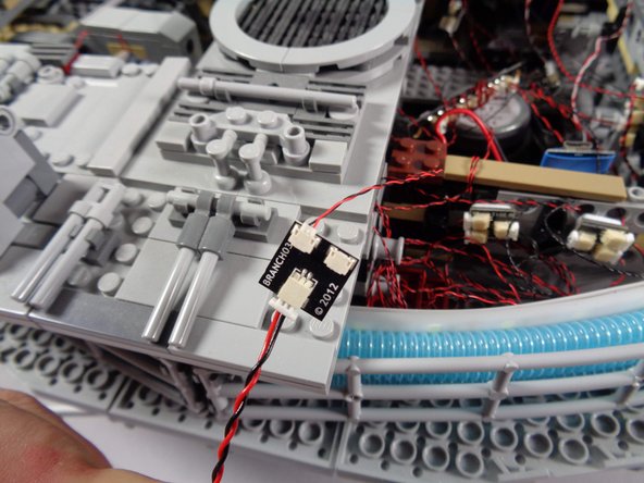 As shown in the second photo, connect one of the two main power supplies for your Falcon light and sound kit to the large plug on the BRANCH03 adapter, and turn the power supply on.  You will use the BRANCH03 adapter to identify each of the five lights you will disconnect.