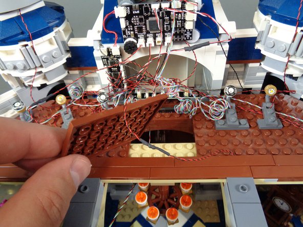 Mount the pre-lit chandelier under the brown floor sections in the same place as the original.