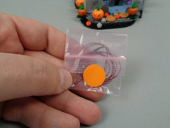 As shown in the first photo for this step, open the small pink bag with the orange dot sticker.