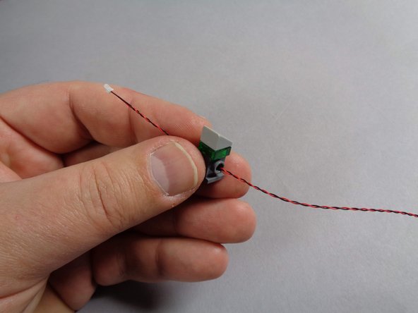 Inside the Main Parts bag, there will be four cool white Pico LED lights with 12&quot; (30.4cm) cables. Take one of these and feed the LED light wire through the hole in the control panel brick as shown in the first photo.