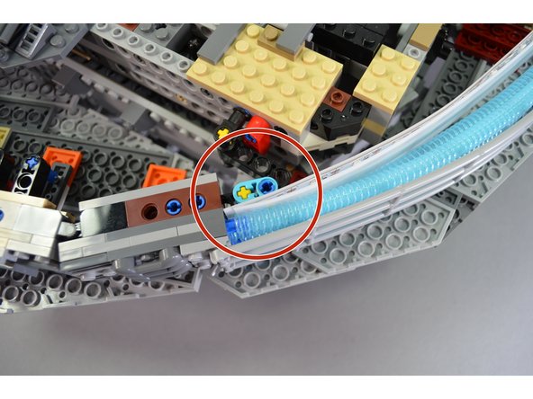 Make sure both the LED panels and the diffuser paper are secured between the turquoise Technic arm and the blue engine tubes as shown by the red circle in the first photo.