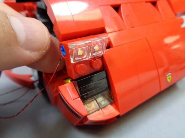 If you mounted the main headlight wires correctly in the previous steps, you should be able to move the main headlights into the fully up position without pulling on the wires as shown in the second photo.