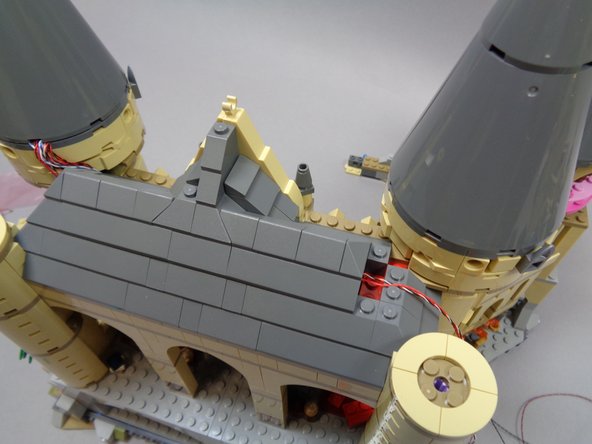 As shown in the second photo, you should now have most of the roof pieces re-attached except for the parts behind the right tower.