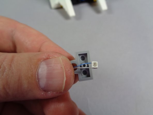 As shown in the second photo, place the square red LED in the center of the 1x2 plate.