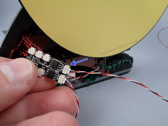 The arrow in the second photo for this step shows the wire from Jack's house connected to the OUTPUT plug of the BRANCH06X board behind the moon section.