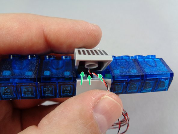 This step is critical.  Carefully place the remaining 2x2 slope on top of the &quot;T&quot; shaped piece so the &quot;T&quot; shaped piece fits up into the back side of the slope part, behind the center hollow tube underneath.  The green arrows in the second photo show where the &quot;T&quot; shaped part should be inserted.