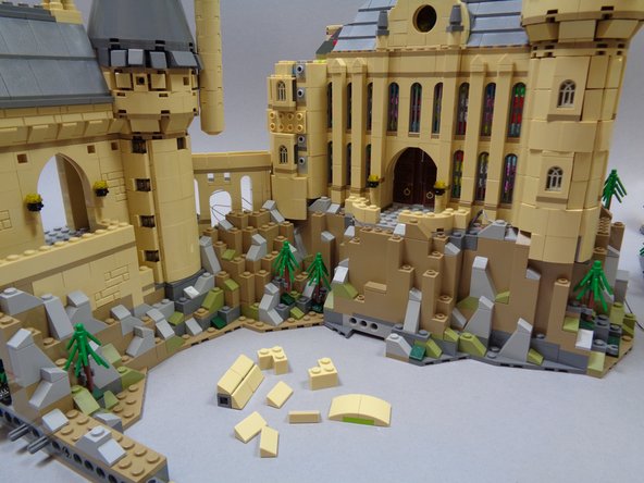 Almost there!  Finish preparing the left tower by removing the tan pieces as shown in the three photos for this step.  This should make the three windows in the tower accessible from the sides so you can insert the three lights.