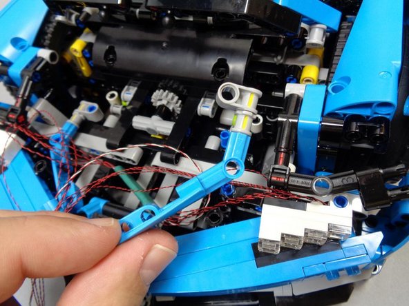 After the headlights have been attached, carefully remove the brackets (on both sides of the car) as shown in the first photo.