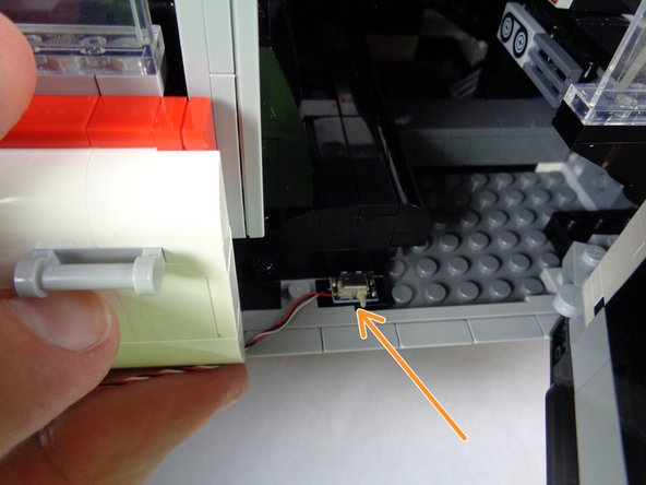 Mount the third door switch as shown by the orange arrow in the first photo for this step.