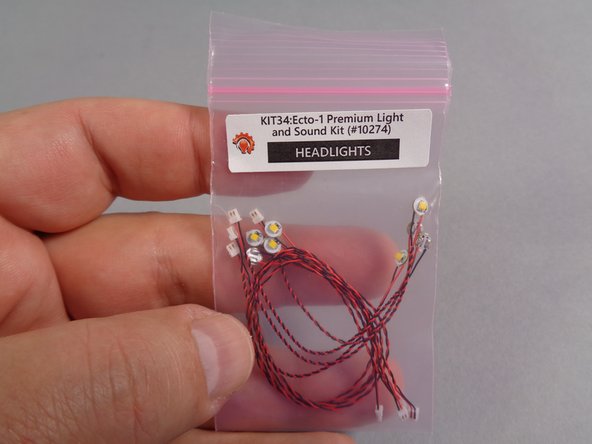 As shown in the second photo for this step, take the smaller pink bag labeled &quot;HEADLIGHTS&quot; out of the &quot;MAIN CHASSIS PARTS&quot; bag.
