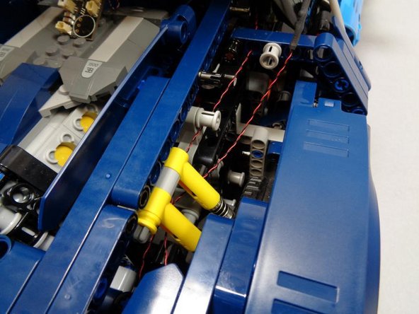 As shown in the third photo, after routing both tail light wires, you should have both cables in the center rear of the car, close to the master control board.