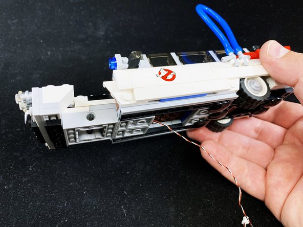 Remove the pre-assembled Brickstuff hood assembly from its anti-static bag, and mount onto the front of the Ecto-1 as shown in the third photo.