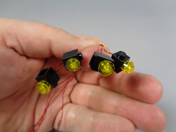 It is ok to press the transparent yellow plates on top of the lights.  Just make sure the light boards are sitting flat on top of the black studs of each brick before attaching the transparent yellow round plate.