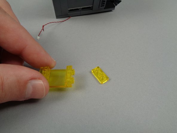 As shown in the first photo for this step, remove one of the top 1x2 transparent yellow plates from the top of the window.