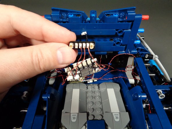 As shown in the first photo for this step, re-connect the interior fiber optic light to one of the two remaining small plugs on the BRANCH15 adapter board.