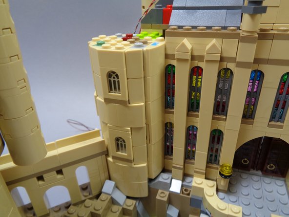 Almost there!  Finish preparing the left tower by removing the tan pieces as shown in the three photos for this step.  This should make the three windows in the tower accessible from the sides so you can insert the three lights.