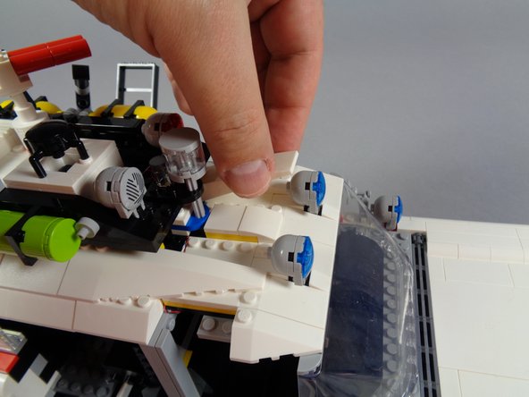 As shown in the second and third photos for this step, you can then re-attach the two long white slopes that connect the front and back roof sections.