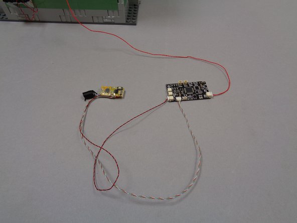 As shown by the green arrow in the second photo, connect the small 4-wire plug from the remote receiver to the plug on the TRUNK08 master controller labeled &quot;REMOTE&quot;.