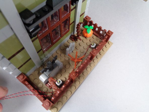 As shown in the third photo, re-attach the fence section with the wires for both LED lights extending to the left.