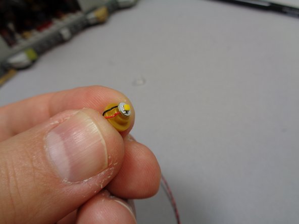 As shown in the photos for this step, remove the lamp assembly, remove the clear round top part, and place a warm white light on top of the stud of the gold piece.