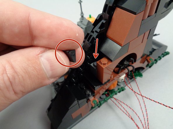Carefully remove the large slope and hinge section as shown by the green arrows in the first photo for this step.