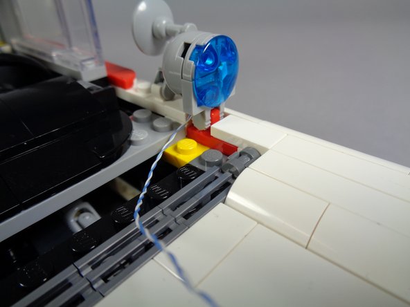 As shown in the second photo, re-attach the hood spot light.