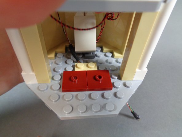 As shown in the second photo, re-attach the floor parts in the lower room, being careful to install them one stud forward from where they were originally installed.