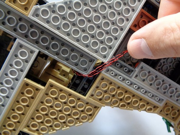 As shown in the second and third photos, take the four flame wires and carefully run them under the base as shown.