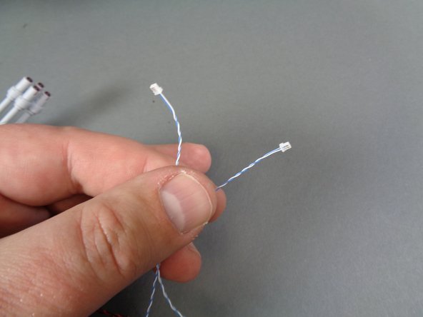 The laser cannon in your kit will have one of two different types of connectors.  The first photo shows the first type of connector-- these are small Pico connectors with blue and white wires.