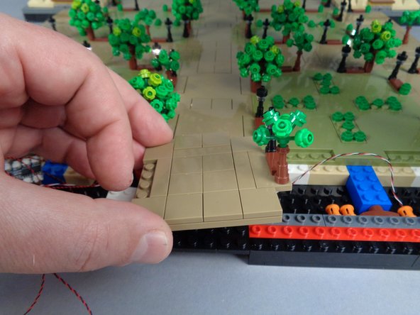 As shown in the photos for this step, re-attach the small panel between Sections 1 and 2 that you removed earlier.