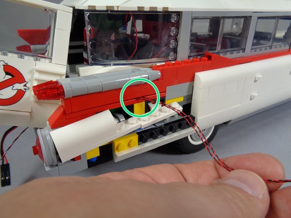 After you have re-attached the tail light assembly, replace the large red fin on top as shown in the third photo.