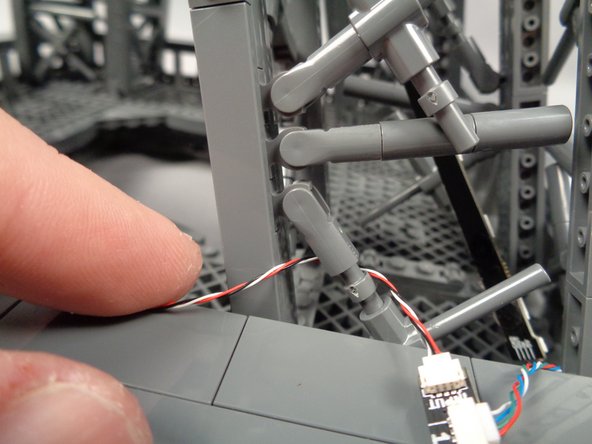 As shown in the third photo, re-attach the "X" crossbar with the control cable passing behind it.