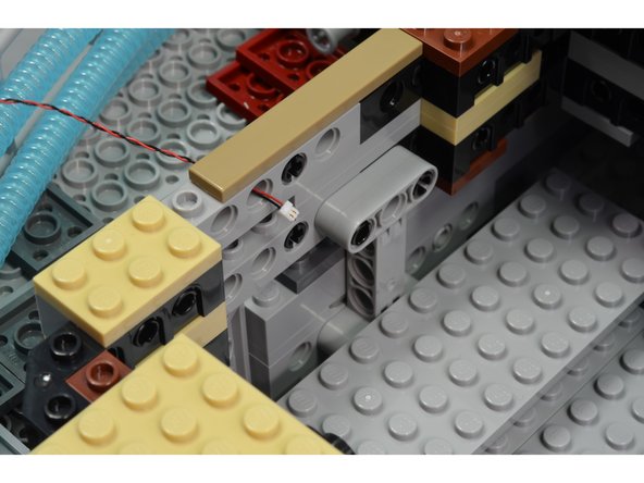 The first photo in this step shows that wires with Pico connectors can pass through stud holes, and the second photo shows that Pico connectors can even pass through Technic pins inserted into stud holes.