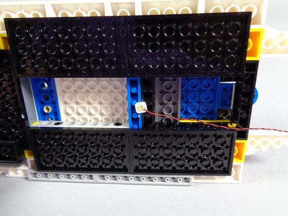 As shown in the third photo for this step, attach one of the LED lights to the center of the underside of the roof.  The third photo shows the LED light wire passing off toward the front of the roof-- this is how your LED light should be mounted as well.