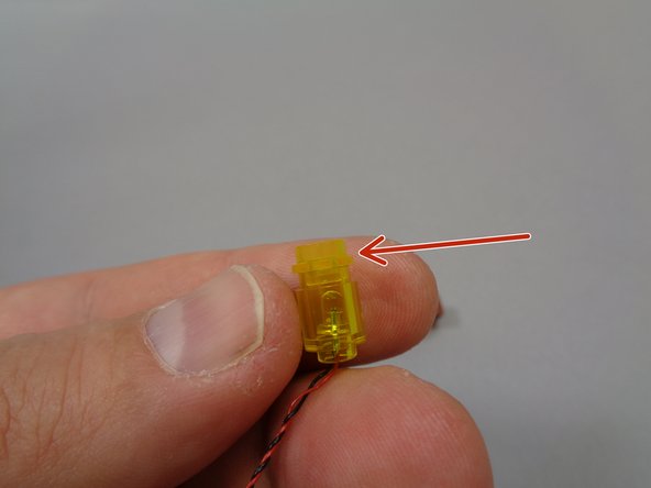 As shown by the red arrow in the second photo, attach the transparent yellow round 1x1 plate to the top of the pre-lit lantern assembly.